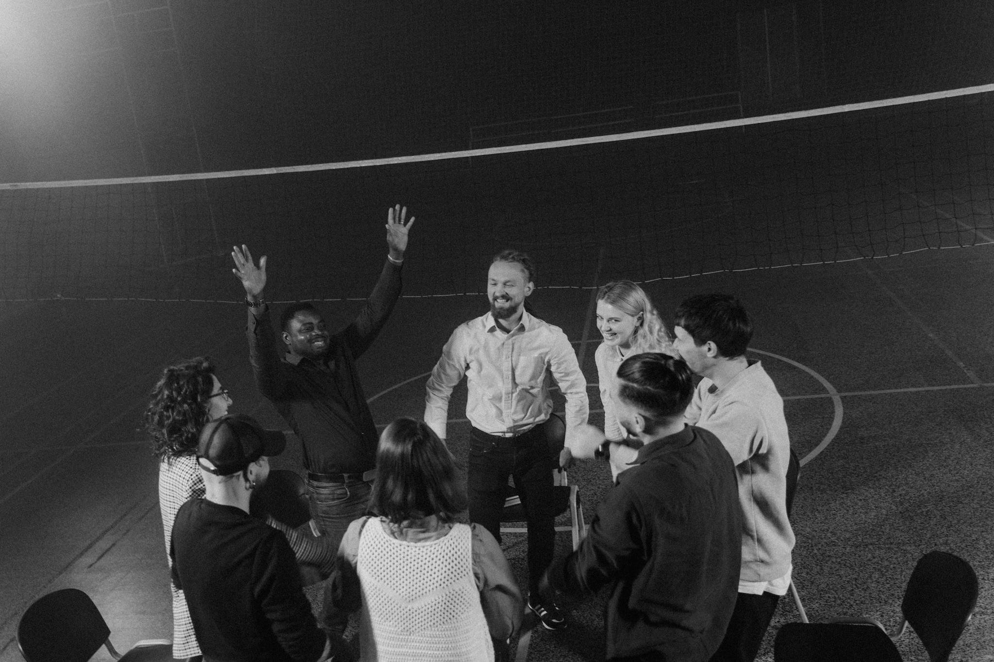 A diverse group of people in a team building huddle indoors, fostering togetherness and support.